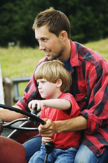 Father and on driving tractor