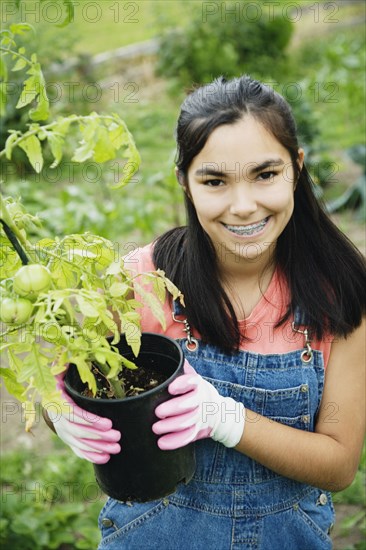 Girl holding tomato plant