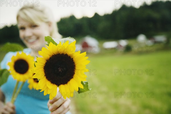 Woman holding sunflowers on farm