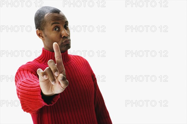 African man holding index finger up and pursing lips