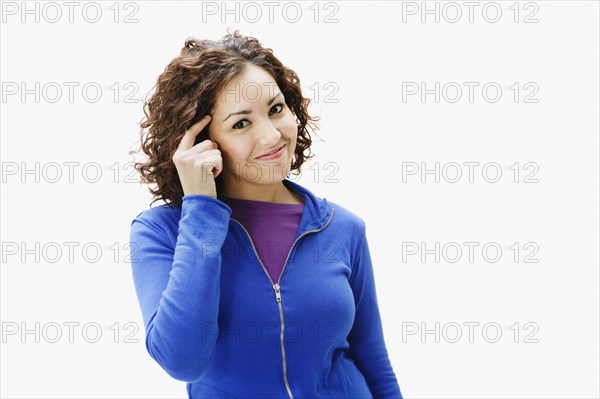 Portrait of woman pointing at temple