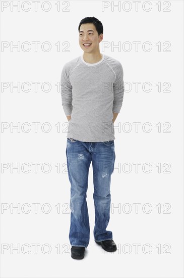 Portrait of Asian man with hands behind back