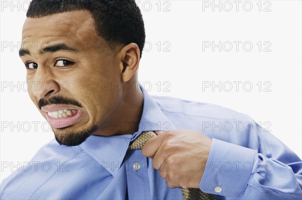 African businessman pulling at necktie