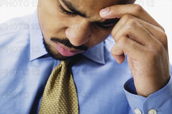 Close up of African businessman with head in hand