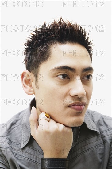 Portrait of Pacific Islander man leaning chin on fist