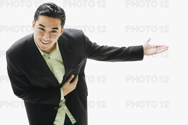 Asian man bowing with arm out