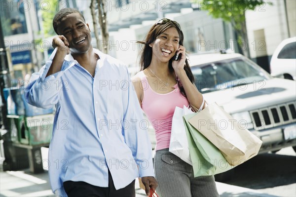 African couple talking on cell phones