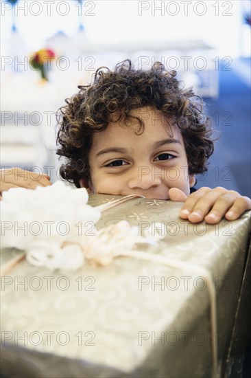 Hispanic boy looking over gift