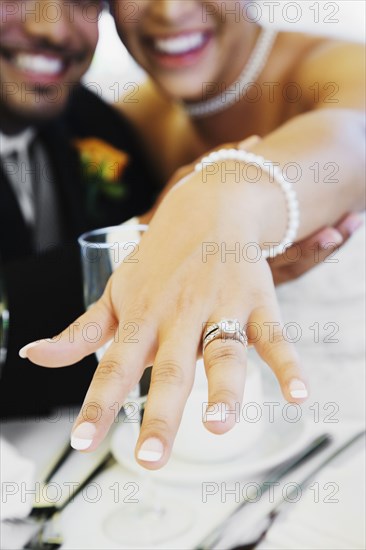 Multi-ethnic bride and groom showing ring