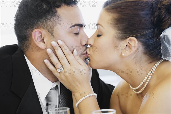 Multi-ethnic bride and groom kissing