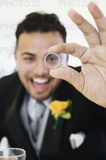 Hispanic groom showing ring