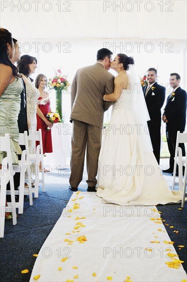 Bride kissing father in aisle