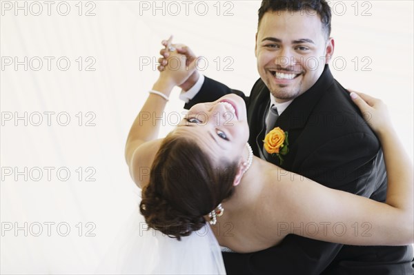 Multi-ethnic bride and groom dancing