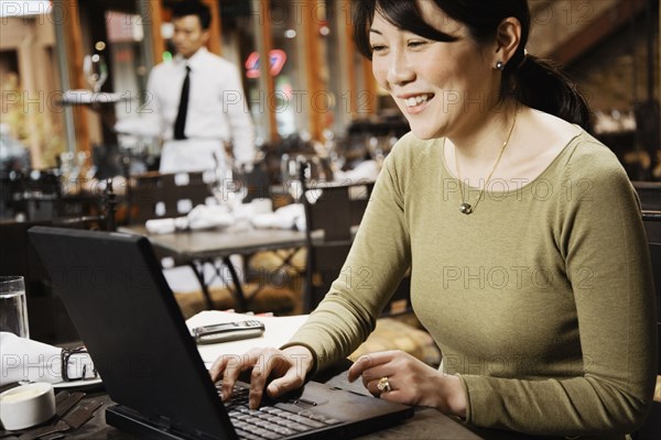 Asian businesswoman typing on laptop