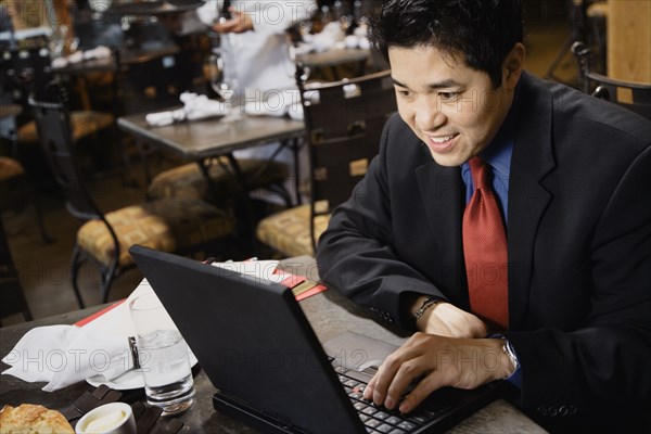 Asian businessman typing on laptop