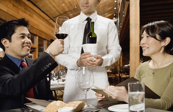 Asian man testing wine at restaurant