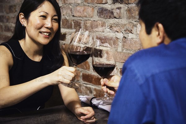 Asian couple toasting with wine