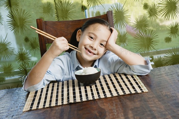 Asian girl eating bowl of rice