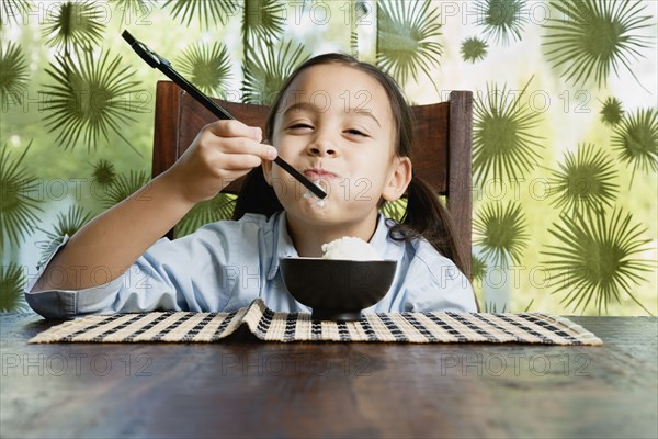 Asian girl eating bowl of rice