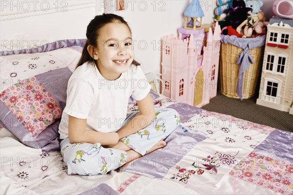 Asian girl sitting on bed