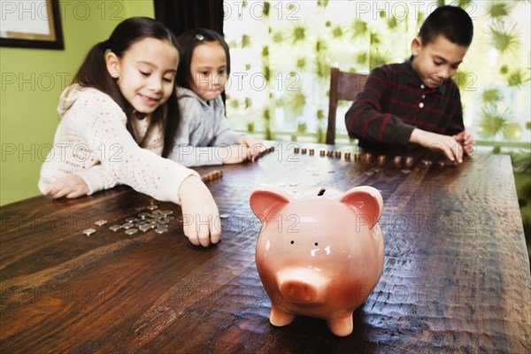 Asian siblings counting coins