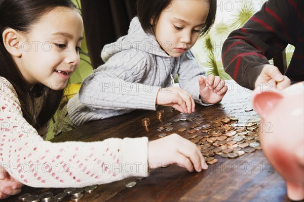Asian siblings counting coins