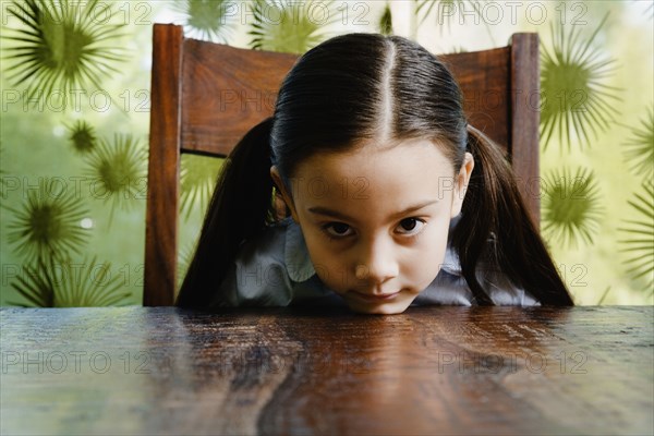 Asian girl resting chin on table