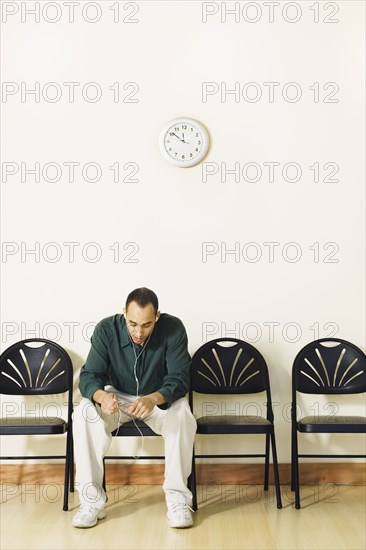 Mixed Race man sitting in waiting area