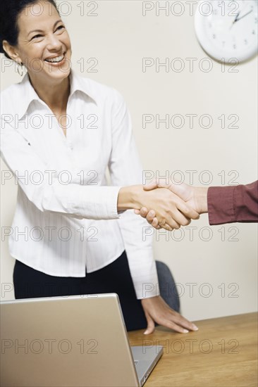 Mixed Race businesswoman shaking hands