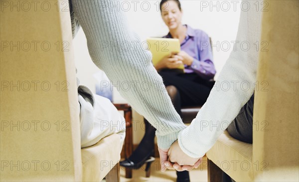 Multi-ethnic couple holding hands at therapy session