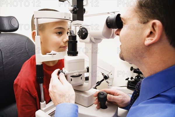 Asian boy having eyes examined