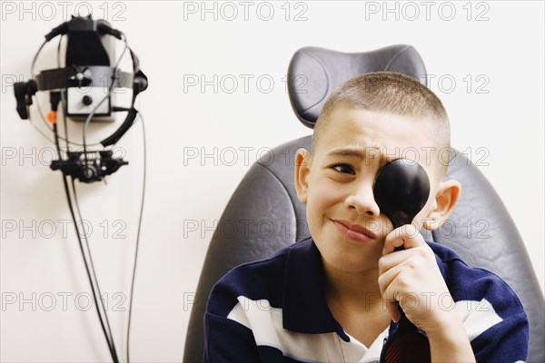 Asian boy taking eye exam