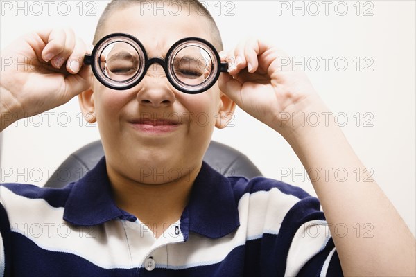 Asian boy taking off eye glasses
