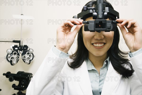 Asian female optometrist wearing examination equipment