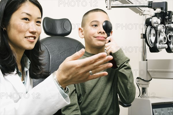 Asian female optometrist examining patient