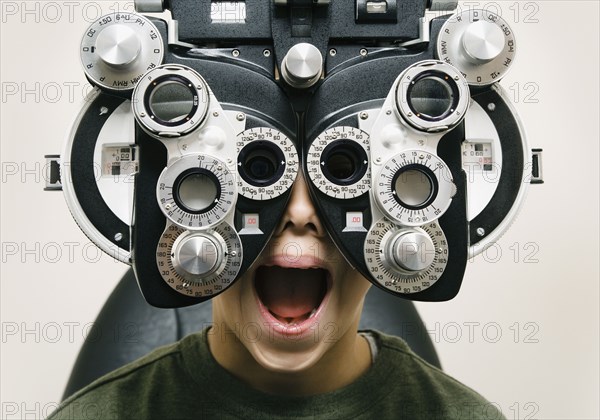 Asian boy having eyes examined