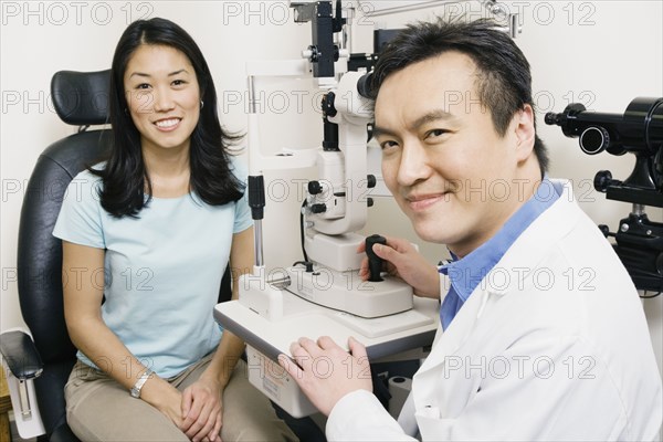 Asian male optometrist examining patient