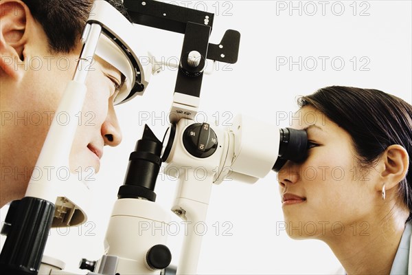 Asian female optometrist examining patient