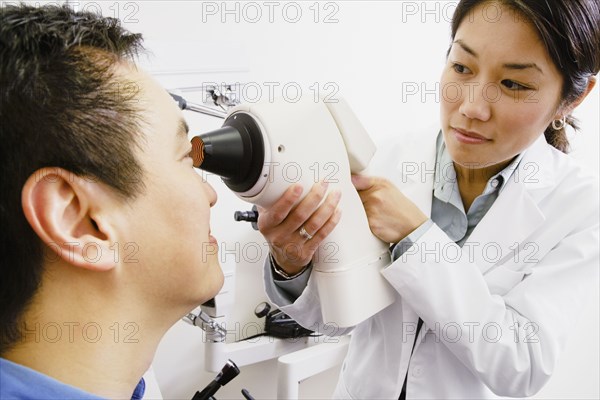 Asian female optometrist examining patient