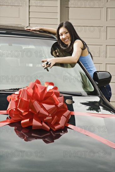 Asian teenager adoring new car