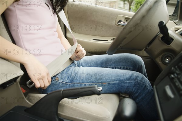 Asian teenager buckling seat belt