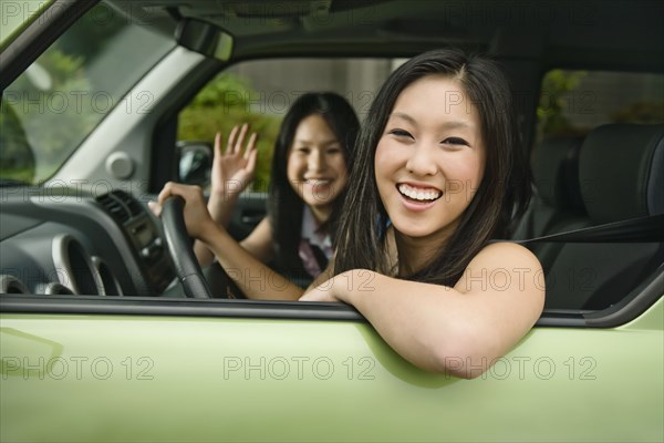 Asian teenagers driving in car