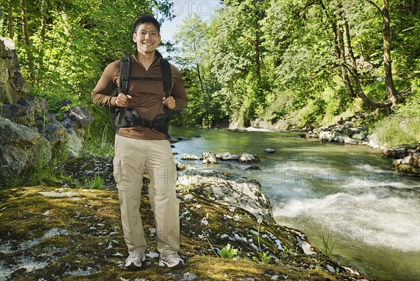 Mixed race man hiking near river