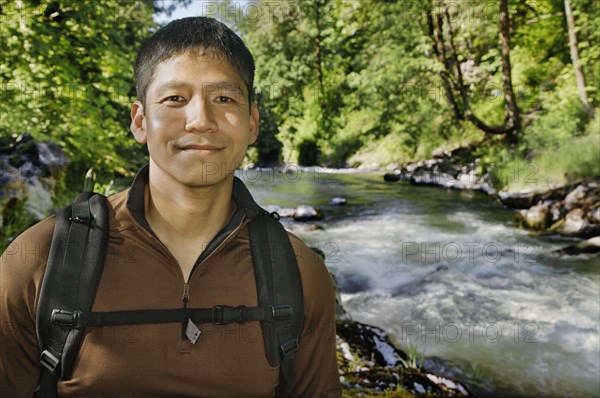 Mixed race man hiking near river