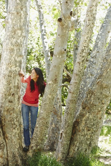 Hispanic woman standing in grove of trees