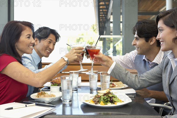 Multi-ethnic friends toasting at restaurant