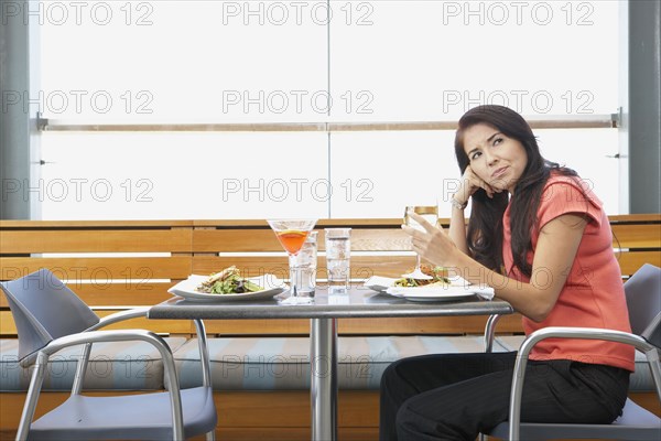 Asian woman waiting at restaurant table