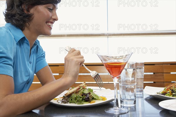 Hispanic woman eating at restaurant