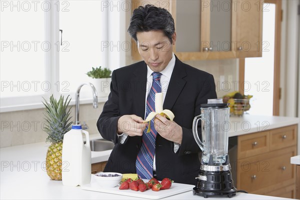 Asian businessman making fruit smoothie