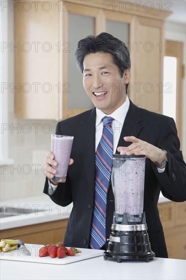 Asian businessman drinking fruit smoothie